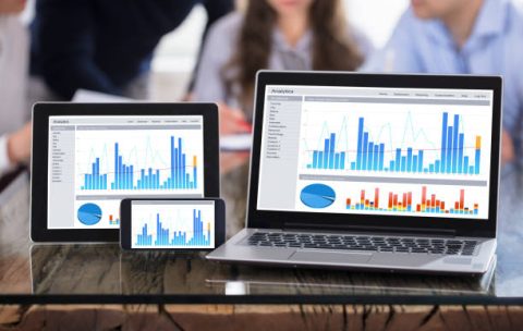 Graph Display On Various Modern Electronic Devices Screen Over The Office Desk